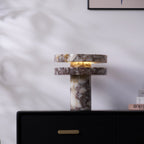 Vertical crop of the lit Clérachic lamp on the dresser, the drawer and brass pull visible directly beneath its base.