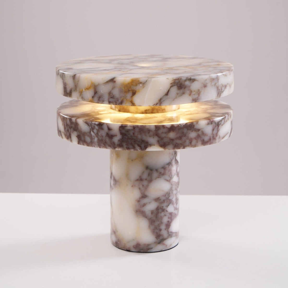 Clérachic lamp photographed unlit and straight-on, its veined marble discs and column base on a plain backdrop.