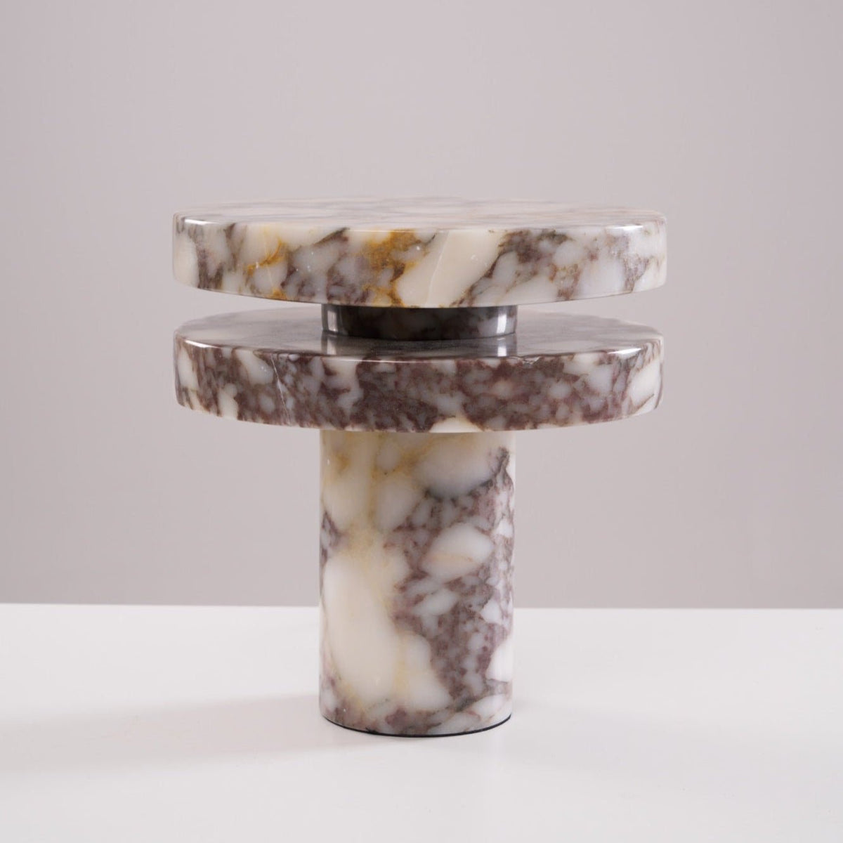 Tighter studio crop of the unlit Clérachic lamp, its stacked marble discs shown straight-on against plain grey.