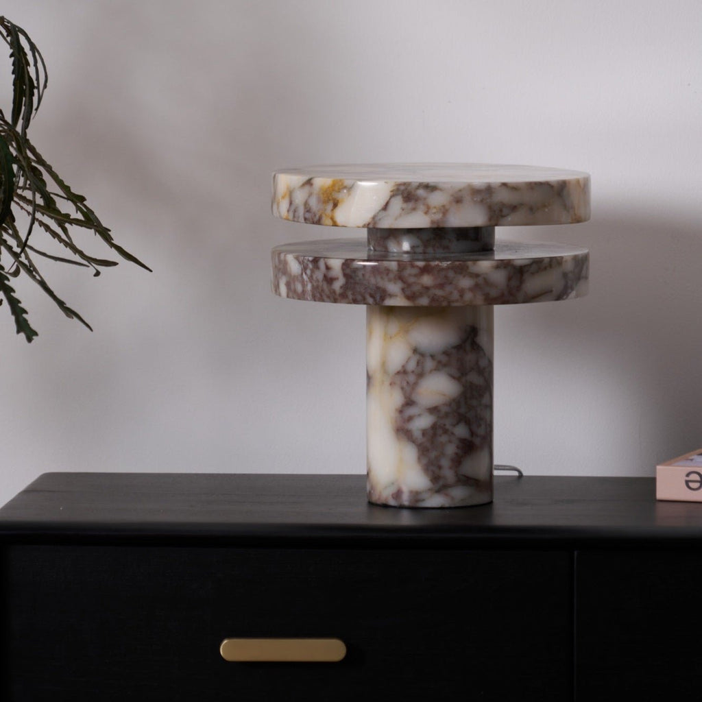Another view of the Clérachic lamp lit on the dresser, more of the eucalyptus branch visible above the marble discs.