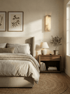Alabaster wall light shown lit against a dark wall