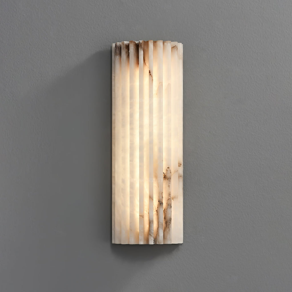 Ribbed alabaster wall light casting a warm stone glow