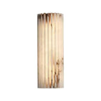 Lit Orcarion alabaster wall light on a white background, showing its tall narrow fluted profile.