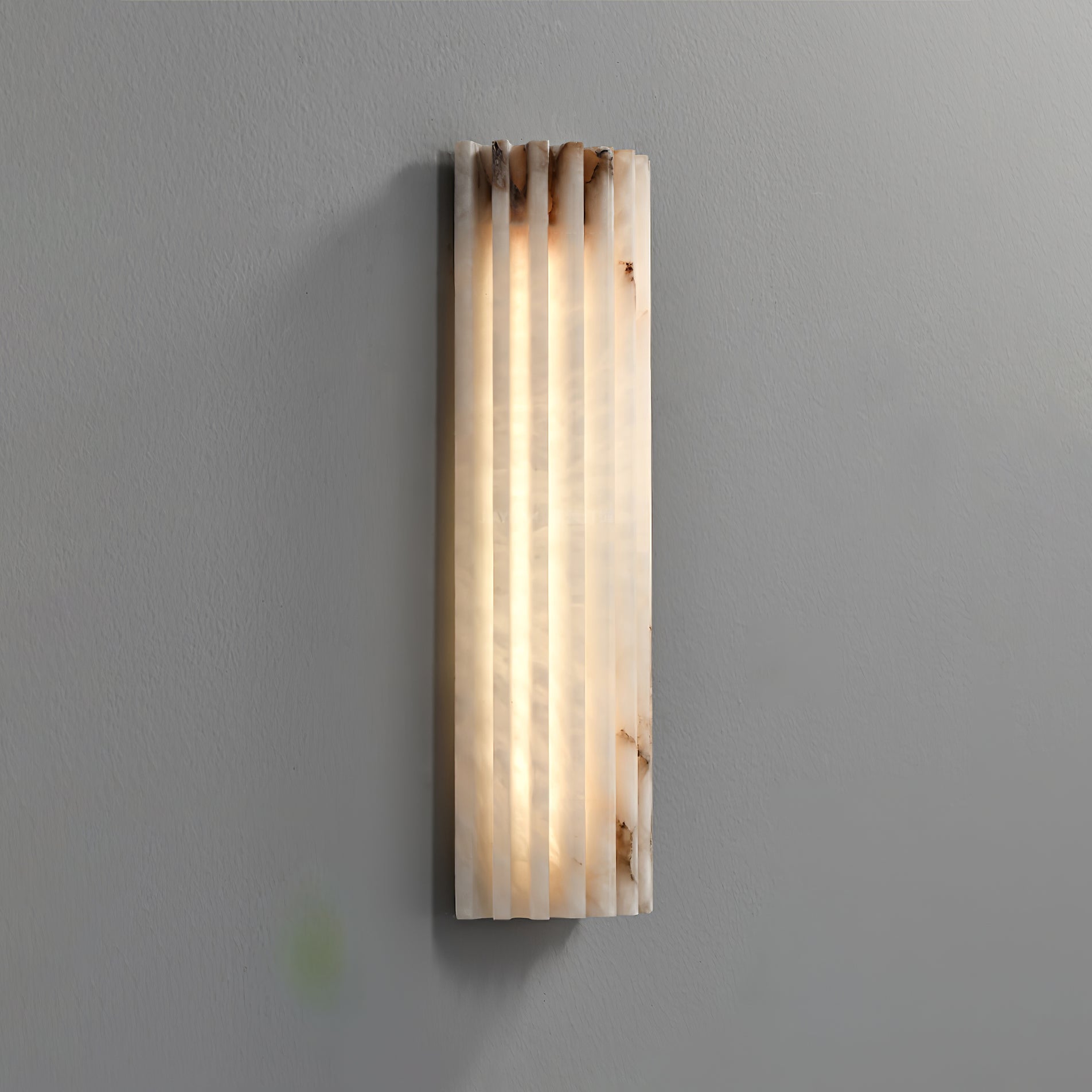 Alabaster wall light mounted beside a doorway at night