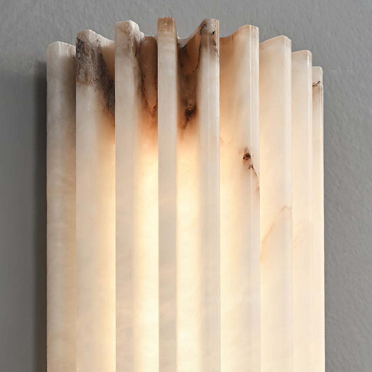 Close-up of the top of the Orcarion wall light, where the chiselled alabaster ribs end in an uneven edge.