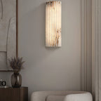 Tighter view of the lit Orcarion wall light in a living room, its stone veining picked out by the glow.