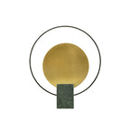 Another studio view of the Clérachic table lamp on white, the black ring framing its brushed gold disc closely.