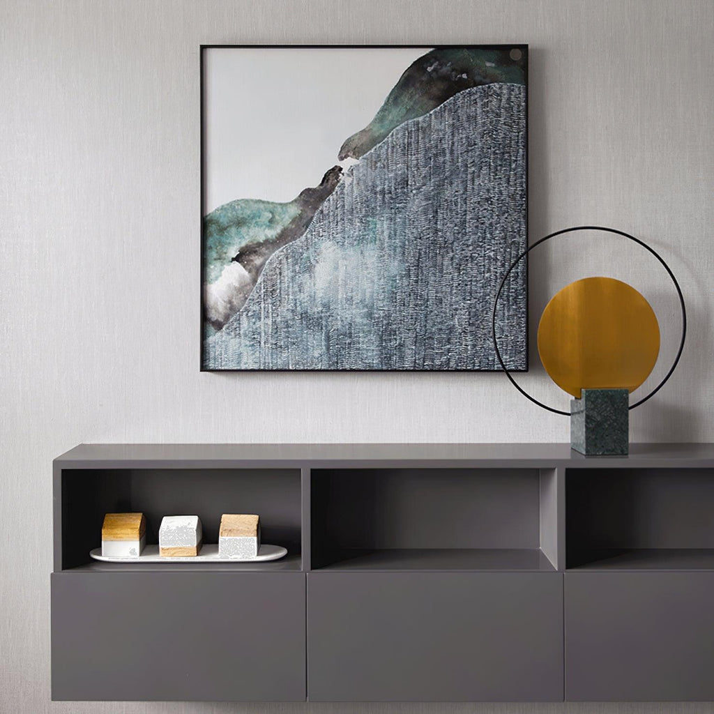 Clérachic table lamp on a grey sideboard, positioned beneath a framed abstract print, its green marble base showing clearly.