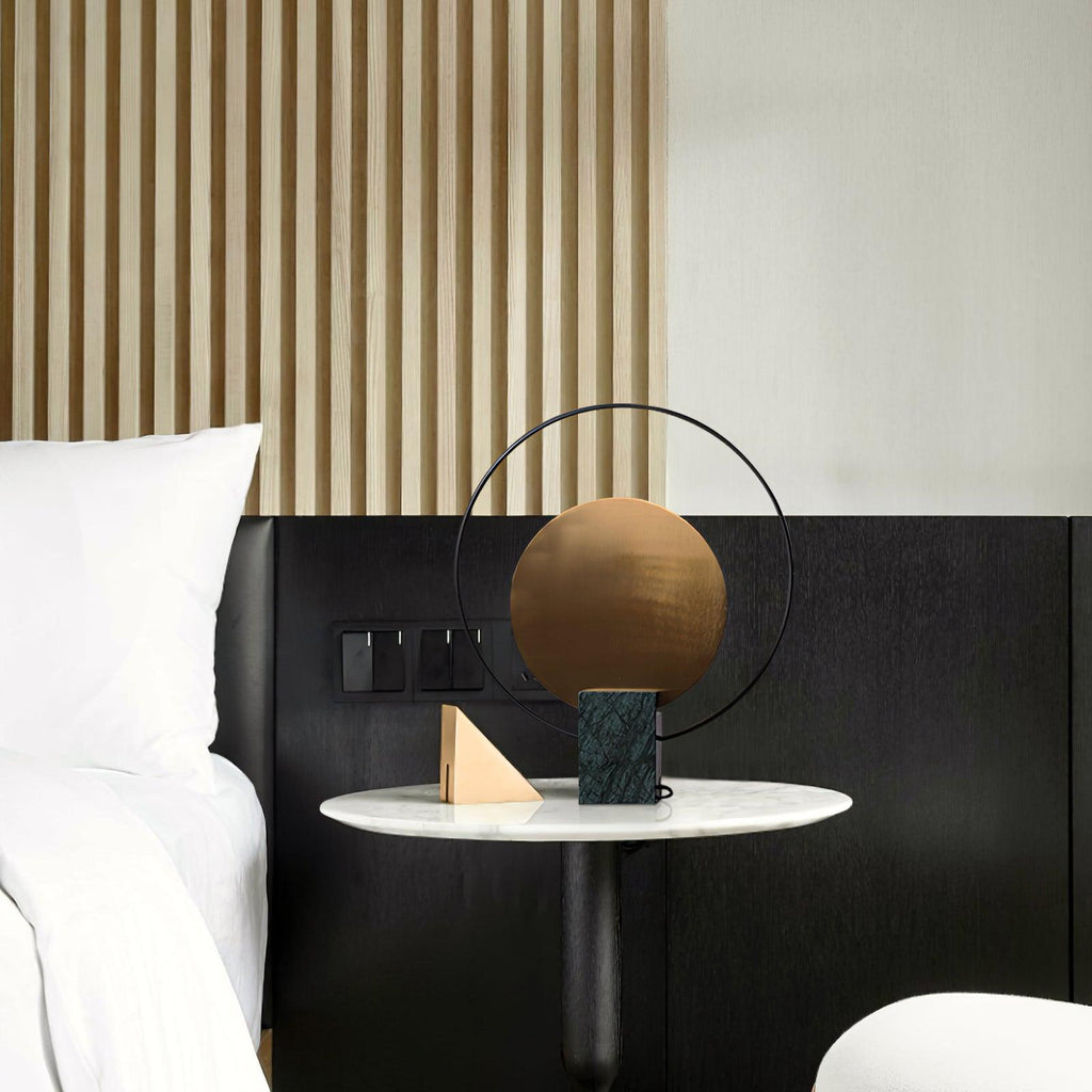 Clérachic table lamp on the same marble-top nightstand, shown unlit in daylight beside the black upholstered bed.