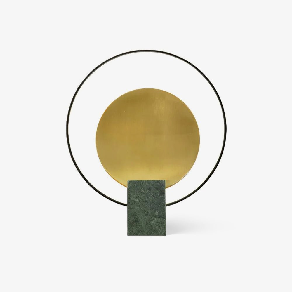 Clérachic table lamp on a plain white background, showing its brushed gold disc inside a black ring above a green marble base.