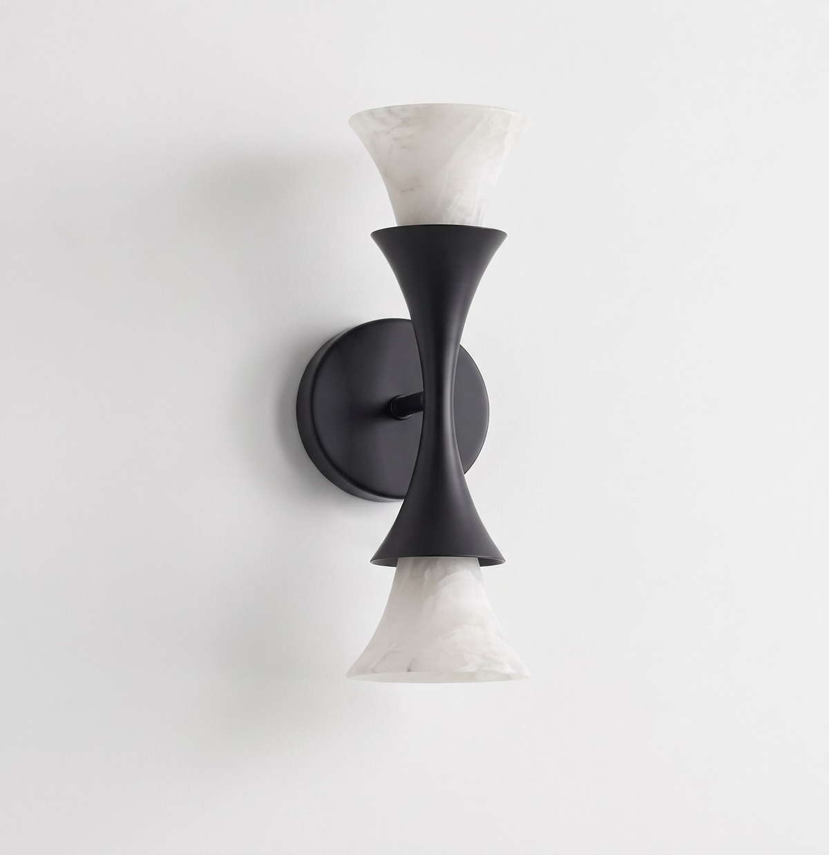 Studio product shot, this Clérachic sconce's matte black hourglass frame holds two alabaster shades against a bare white backdrop.