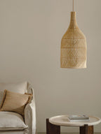 This Clérachic pendant hangs beside a linen sofa with a jute cushion and a wood side table.
