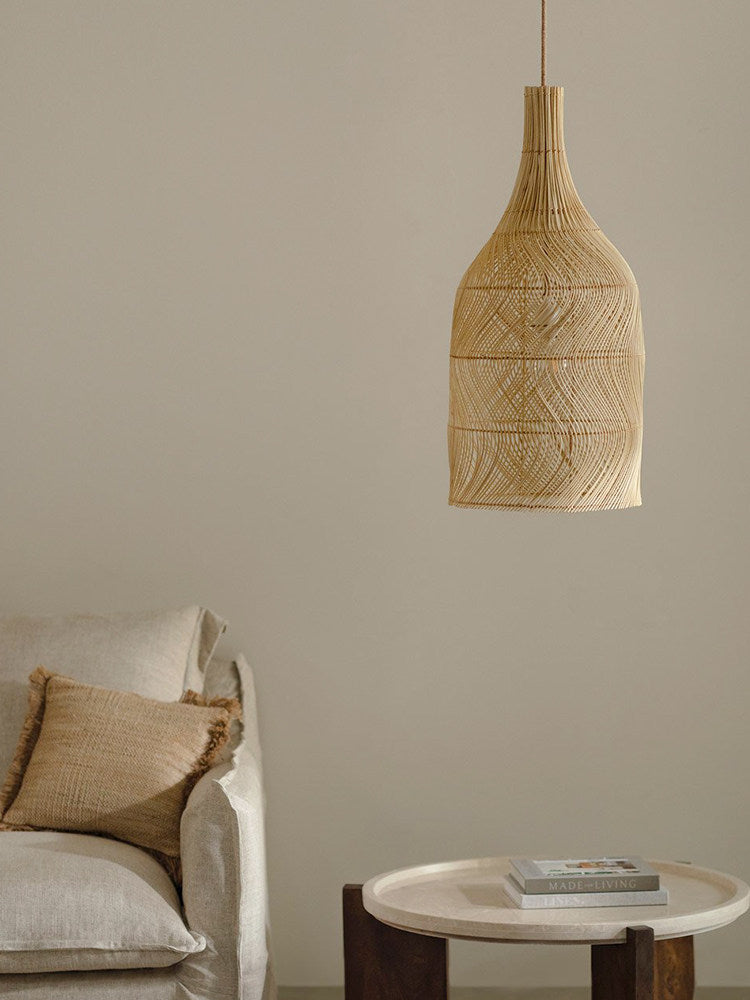 This Clérachic pendant hangs beside a linen sofa with a jute cushion and a wood side table.