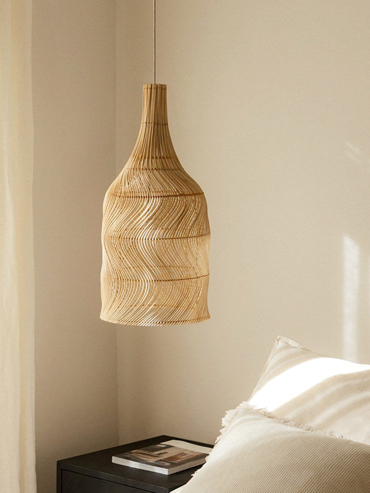 In a bedroom corner, this Clérachic pendant hangs near a bed with white linens and a dark nightstand.