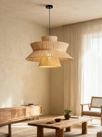 In a living room corner with sheer curtains and a rattan armchair, this Clérachic pendant lights a wood sideboard below.