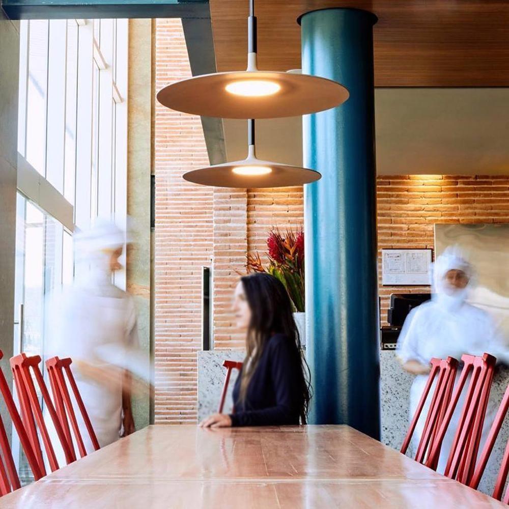 Aluminum pendant light casting a focused pool of light