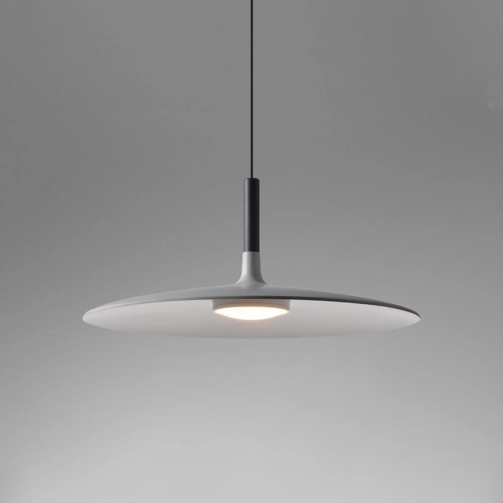 Aluminum pendant light glowing warmly above a dining space