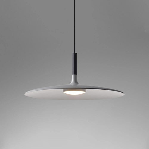 Aluminum pendant light glowing warmly above a dining space