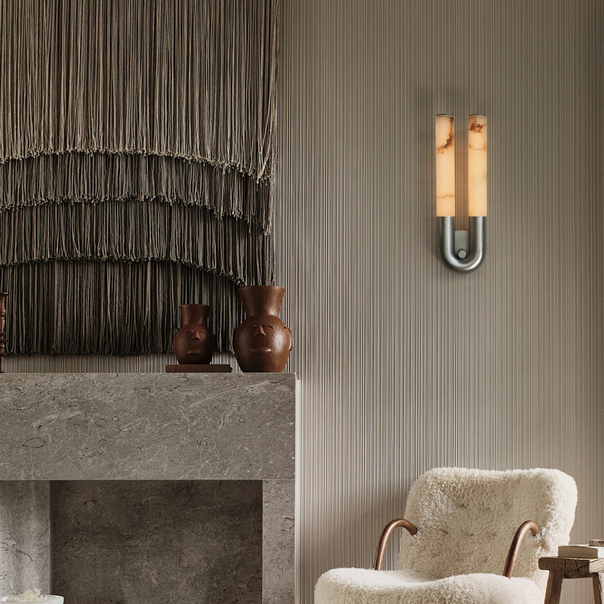 Nickel Arch wall sconce hung arch-down beside a stone fireplace and a sheepskin chair