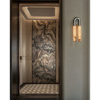 Nickel Arch wall sconce hung arch-up beside a doorway lined with veined marble