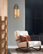 Nickel Arch sconce hung arch-up on a grey wall above a cream boucle armchair by a dark window