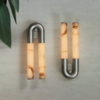 Two nickel Arch wall sconces unlit side by side, one hung arch-up and one arch-down