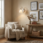 In a room corner with a gallery wall and an upholstered armchair, this Clérachic sconce's brass finish lights a console table.