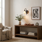 Above a narrow console bench, the black-finish sconce from Clérachic lights a framed piece of wall art nearby.