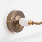 Close view of the porcelain finial and bronze swivel joint on this Clérachic wall sconce.