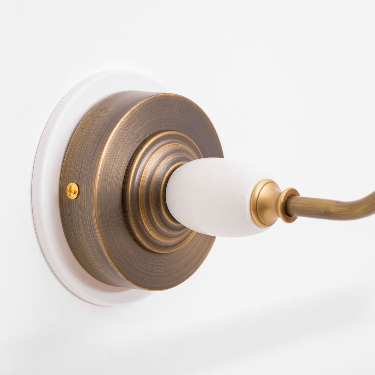 Close view of the porcelain finial and bronze swivel joint on this Clérachic wall sconce.