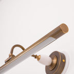 Close view of the bronze bar and curved arm with a porcelain finial on this Clérachic wall sconce, shown at an angle.