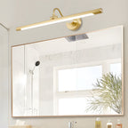 This Clérachic wall sconce in gold mounts above a large mirror in a bathroom, its acrylic shade unlit.