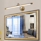 A large ornate mirror, reflecting a sitting room with a floor lamp and sofa, is lit by this gold Clérachic wall sconce.