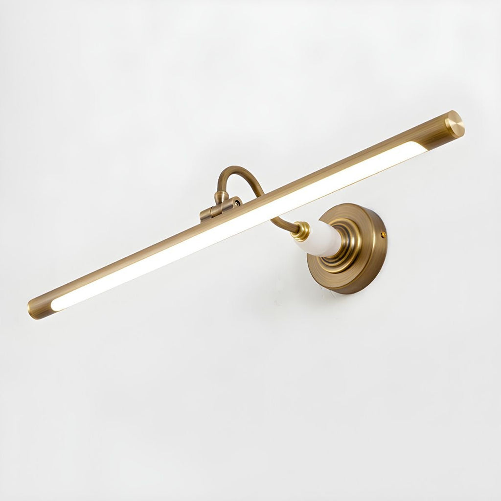This Clérachic wall sconce in gold glows at an angle against a plain white background, its swivel arm visible.