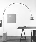 Another angle of the same black-and-white scene shows the Clérachic lamp's chrome dome closer to the sawhorse dining table.