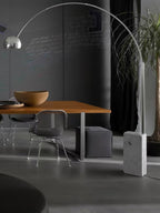 A closer view of the chalkboard-walled dining room shows the Clérachic arc lamp's dome above the wooden table and chairs.