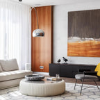 A closer view shows the Clérachic arc lamp's chrome dome against the walnut panel wall beside a striped cream sofa arm.
