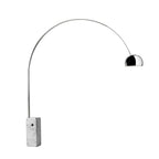 A Clérachic arc floor lamp stands on a plain grey backdrop, its polished chrome dome and marble base catching soft studio light.
