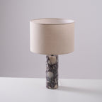 Clérachic marble table lamp photographed straight-on against a plain grey studio background, shade lit from within.