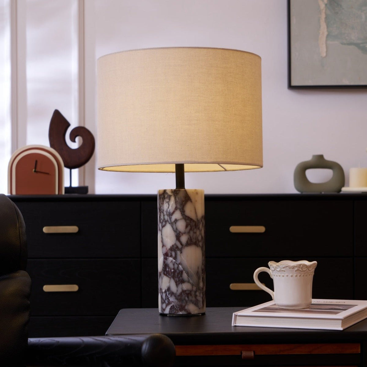 The same sideboard scene as the previous frame, the Clérachic lamp's linen shade lit a touch brighter.