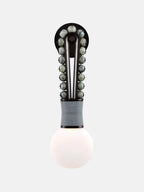 Clérachic wall light with speckled grey stone beads on a brass frame and a grey-wrapped base, on a plain light-grey background.