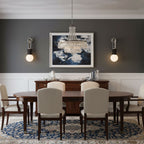 A framed print hangs above the sideboard, flanked by two lit Clérachic wall sconces in a dark grey dining room.