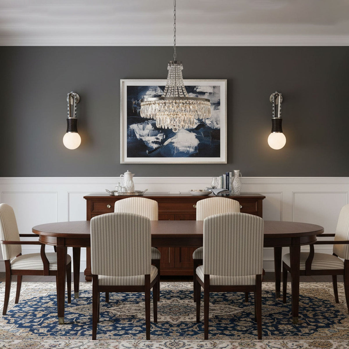 A framed print hangs above the sideboard, flanked by two lit Clérachic wall sconces in a dark grey dining room.