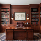 A leather desk sits beneath a framed map, lit either side by two Clérachic wall sconces in a wood-panelled office library.