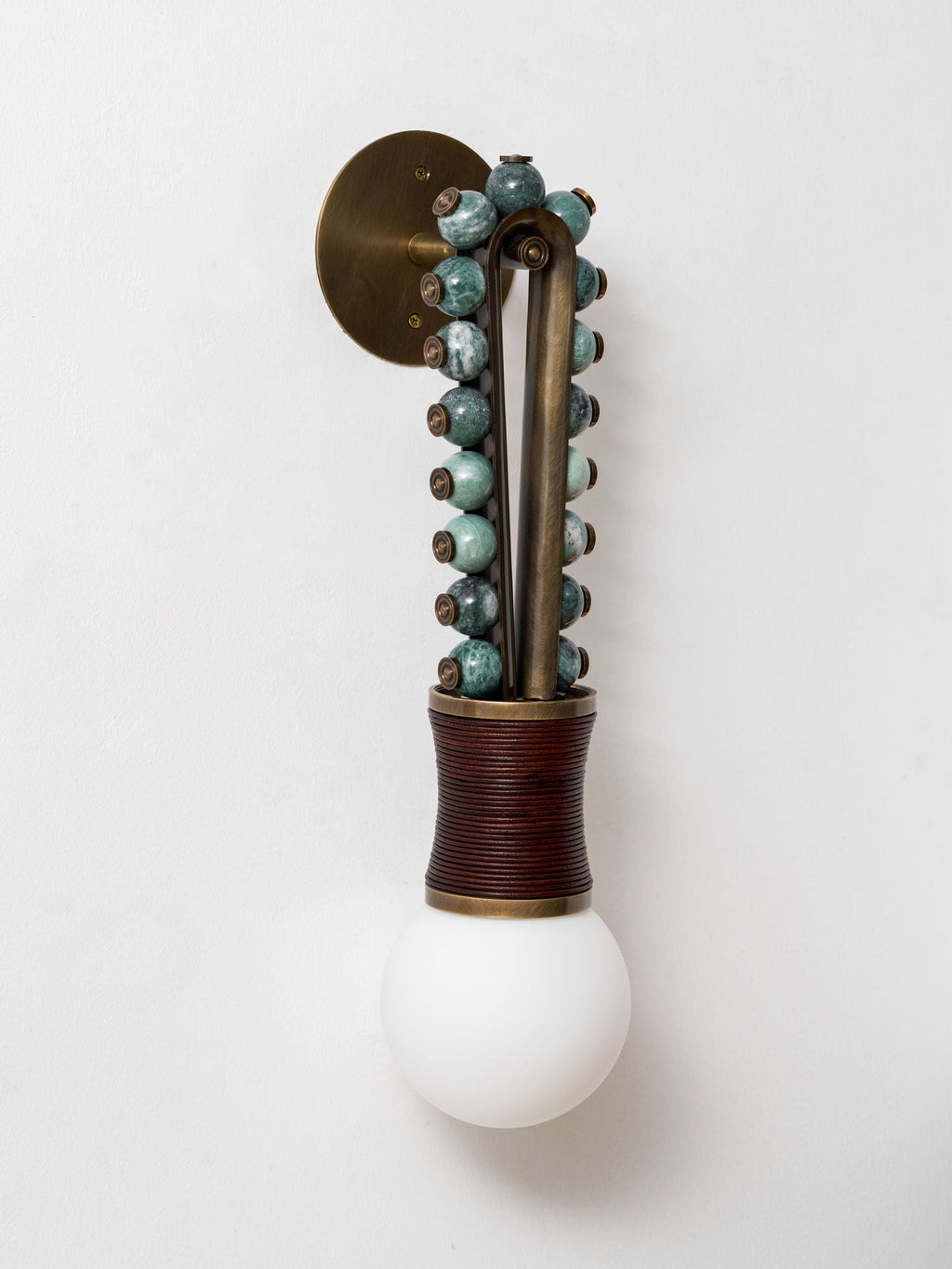 Clérachic wall sconce mounted on a plain wall, a closer crop showing the brass bracket above the sage-bead frame.
