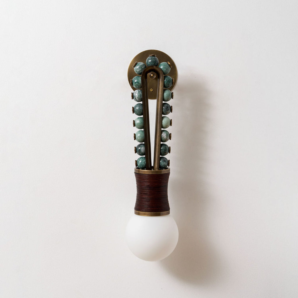 Clérachic wall light mounted on a plain white wall, sage-green stone beads and a maroon-wrapped base shown straight-on.