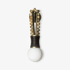 Clérachic wall sconce with mixed grey and tan stone beads on a brass frame and a black-wrapped base, on a white background.