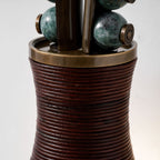 Close-up of a Clérachic wall sconce's marbled green beads and leather-wrapped base, showing the brass collar in detail.
