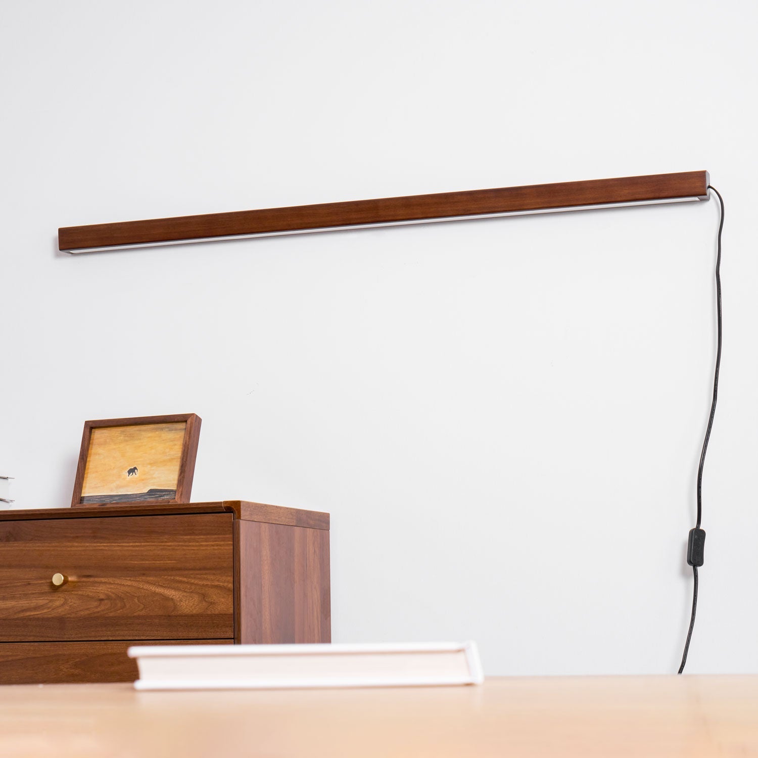 Pine wood disc light shown lit in a calm interior