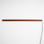 Round wood wall light glowing softly in a warm room